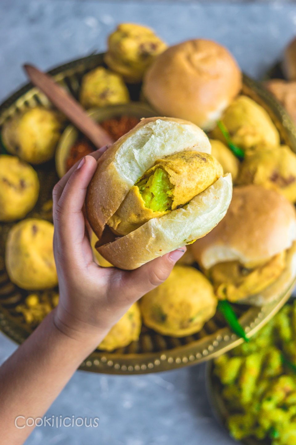 a child holding a Bombay Special Vada Pav in her hand