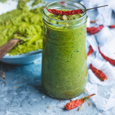 A jar filled with Indian Green Chutney with Leftover Lettuce Leaves and a dried red chilly on top