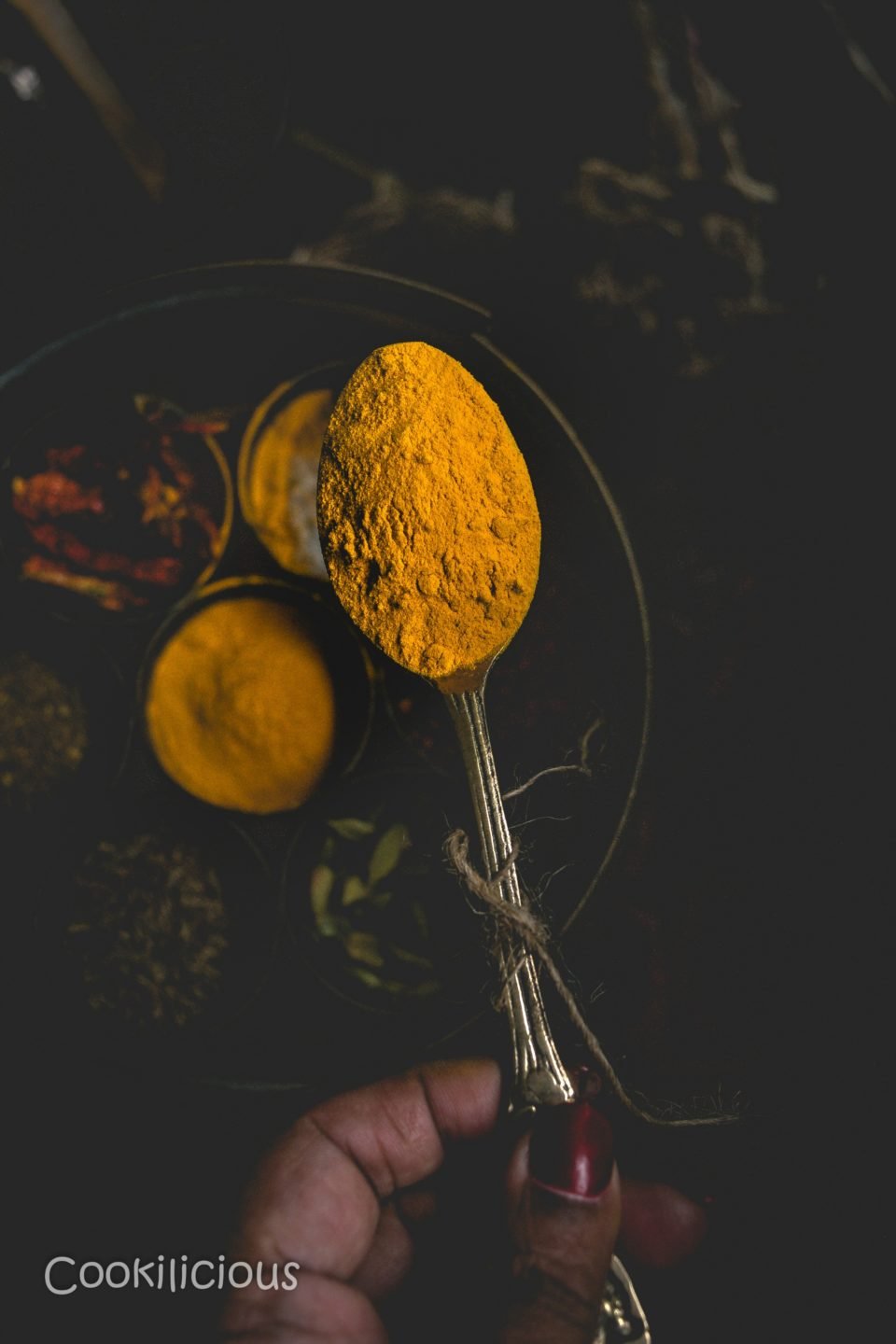 close up shot of a spoonful of turmeric powder