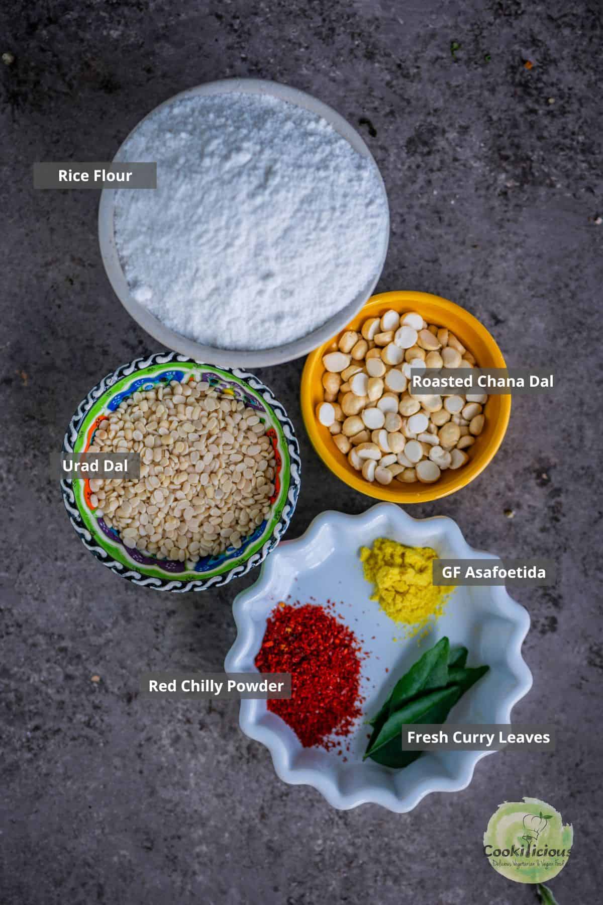 All the ingredients needed to make crispy South Indian Thattai placed on a table with labels on them.