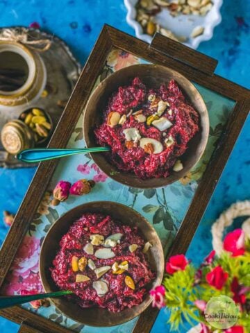 2 bowls of Beetroot Halwa served in a tray with spoons in them