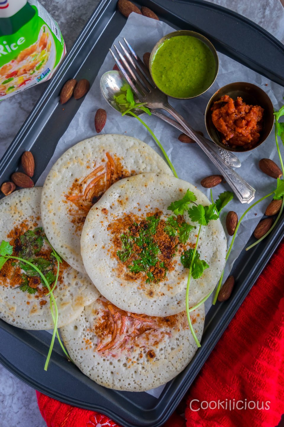 top image of a tray full of uttapam made from dosa batter served with 2 kinds of chutney