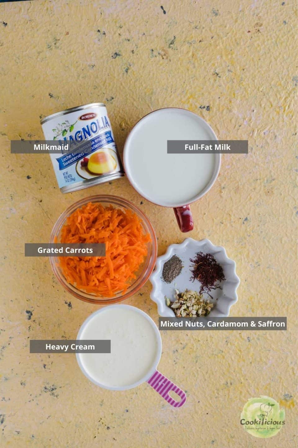 all the ingredients needed to make Carrot Halwa Ice Cream placed on a flatsurface with labels on them