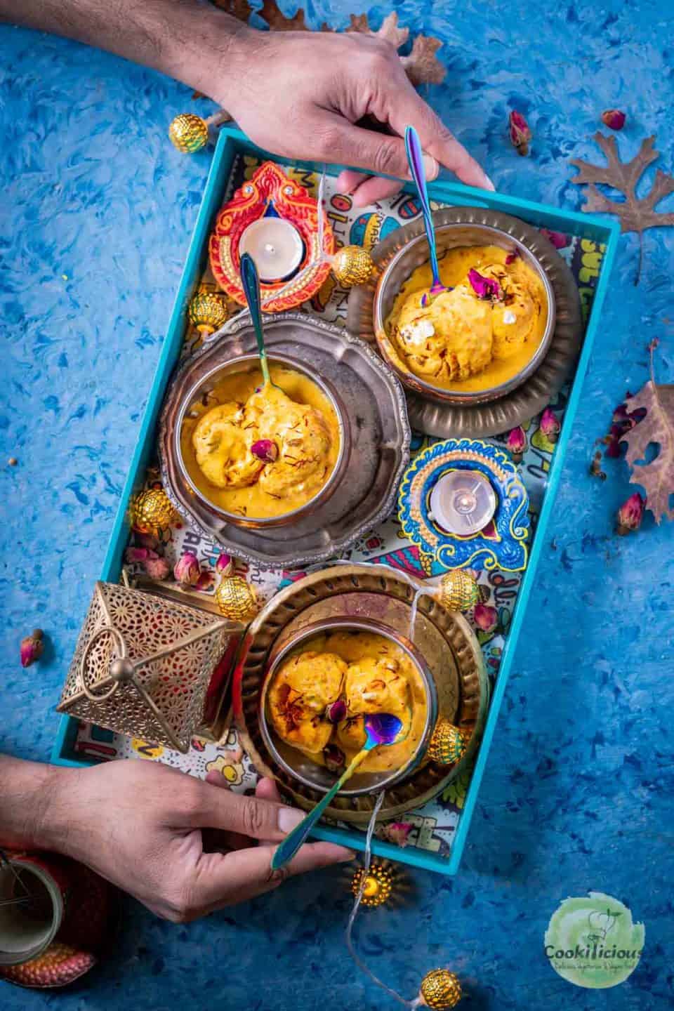 a set of hands holding a tray filled with 3 bowls of Carrot Halwa Ice Cream