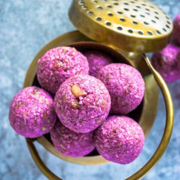 top shot of Frozen Raspberry Date Coconut Balls in a brass bowl