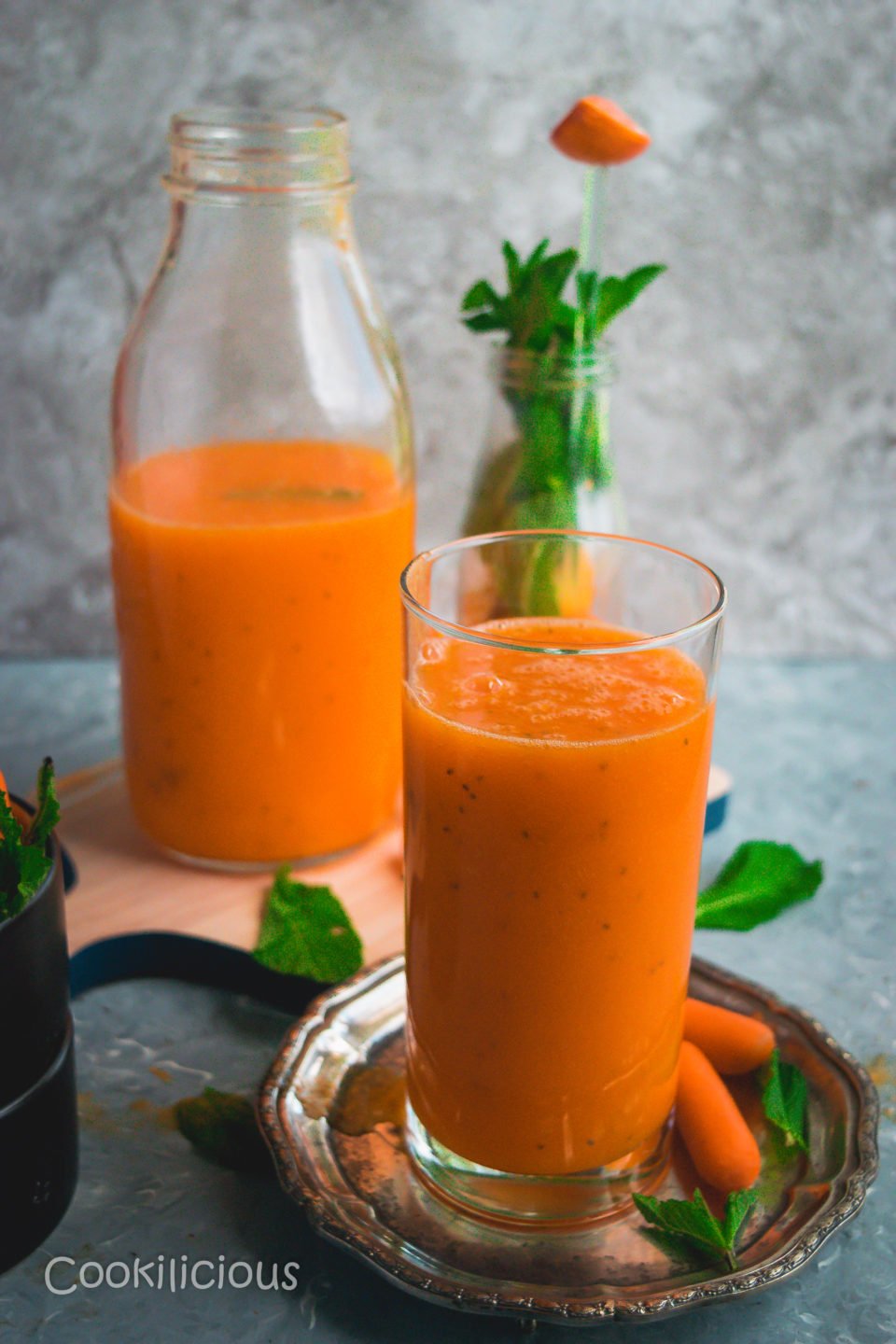 a glass filled with Immune Boosting Sunshine Smoothie and a bottle filled with the same juice in the background