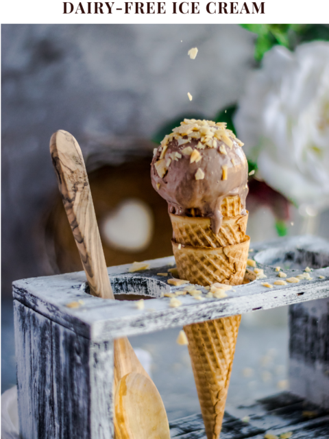 a hand sprinkling coconut chips over a Coconut Chocolate Dairy-Free Ice Cream cone and text on top