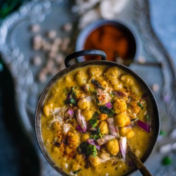 Instant Pot Potato Chickpeas Vegan Curry in a round bowl with a spoon in it