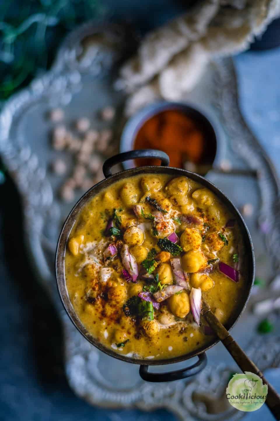 Instant Pot Potato Chickpeas Vegan Curry in a round bowl with a spoon in it