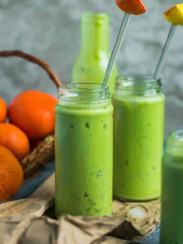 2 glasses of Super Healthy Mango Spinach Yogurt Power Smoothie with a stirrer in each