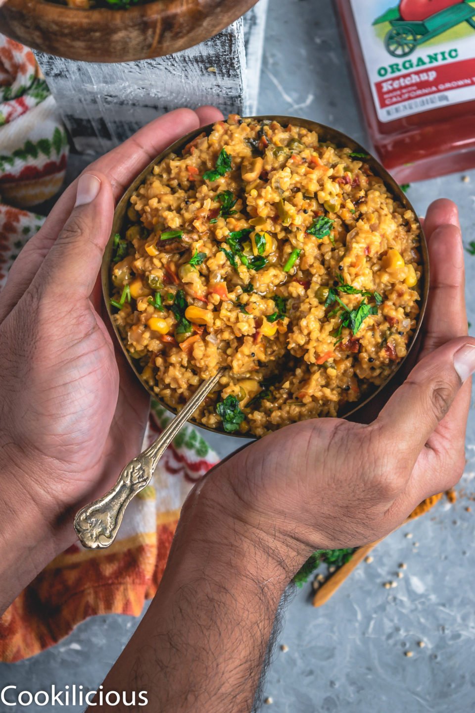 a set of hands wrapped around a bowl of Instant Pot Oats & Vegetable Upma