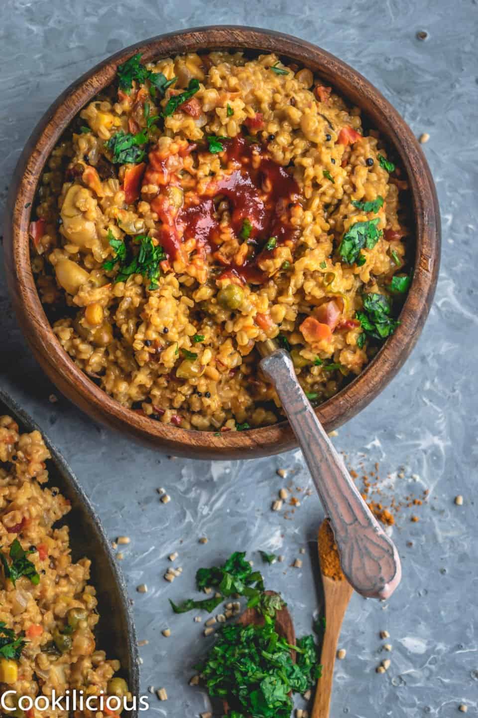 a bowl of Instant Pot Oats & Vegetable Upma with ketchup in the middle