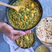 a set of hands holding a bowl of Green Beans & Potato Gravy