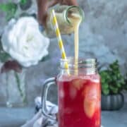 a hand pouring guava juice over a glass to make Fresh Guava & Watermelon Non Boozy Summer Drink