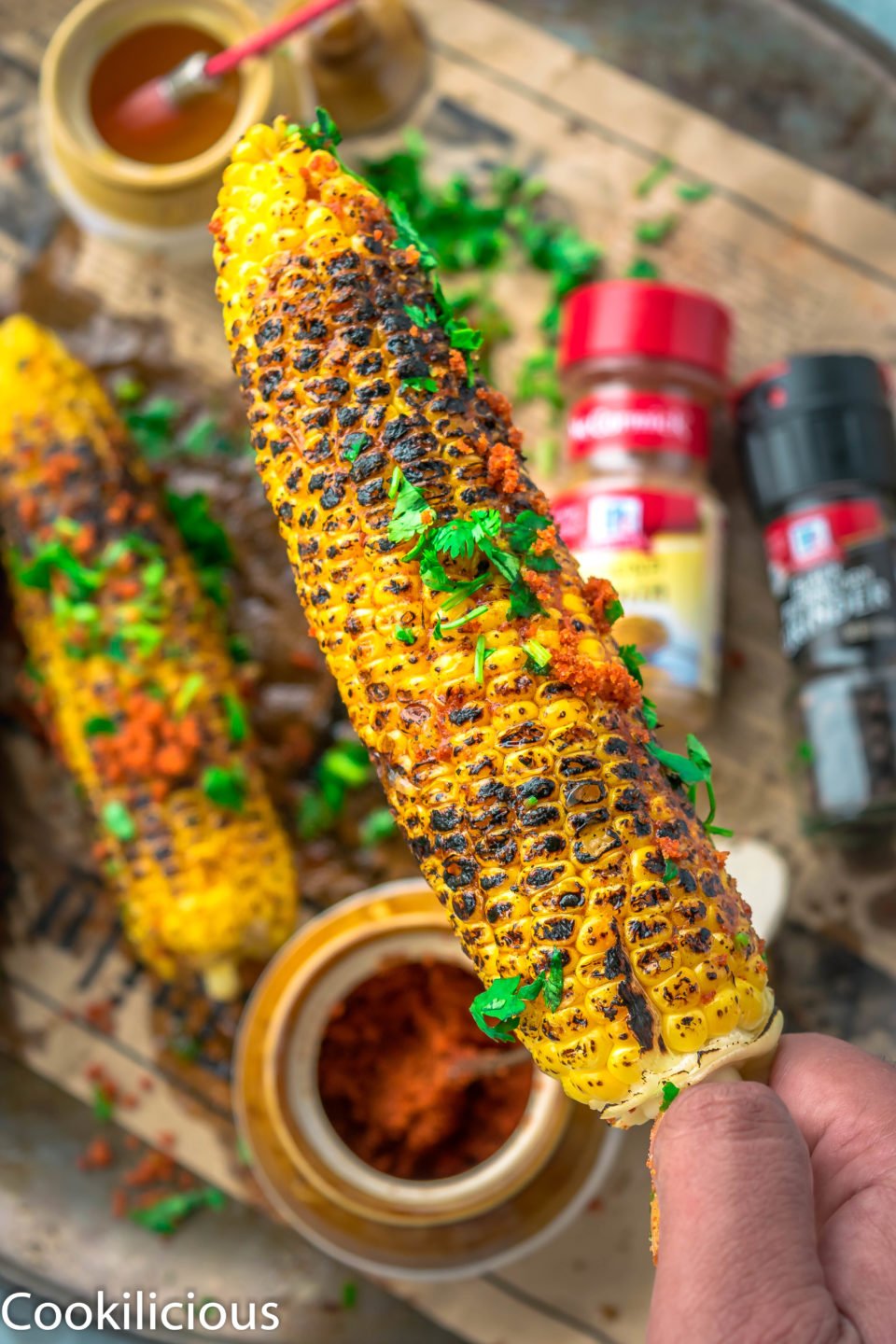 a hand holding a Indian Street Style Corn On The Cob