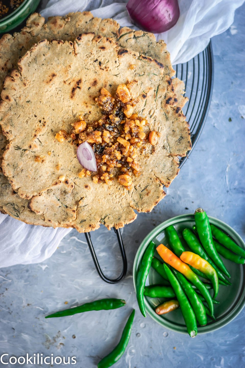 top angle shot of Dill Flavored Jowar Bhakri with a bowl of green chillies on the side