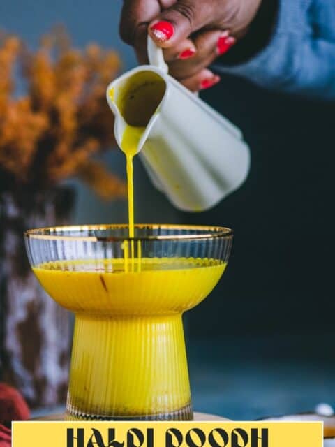 A hand pouring golden milk in a glass and text at the bottom.