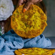 a hand lifting one protein pancake from a plate.