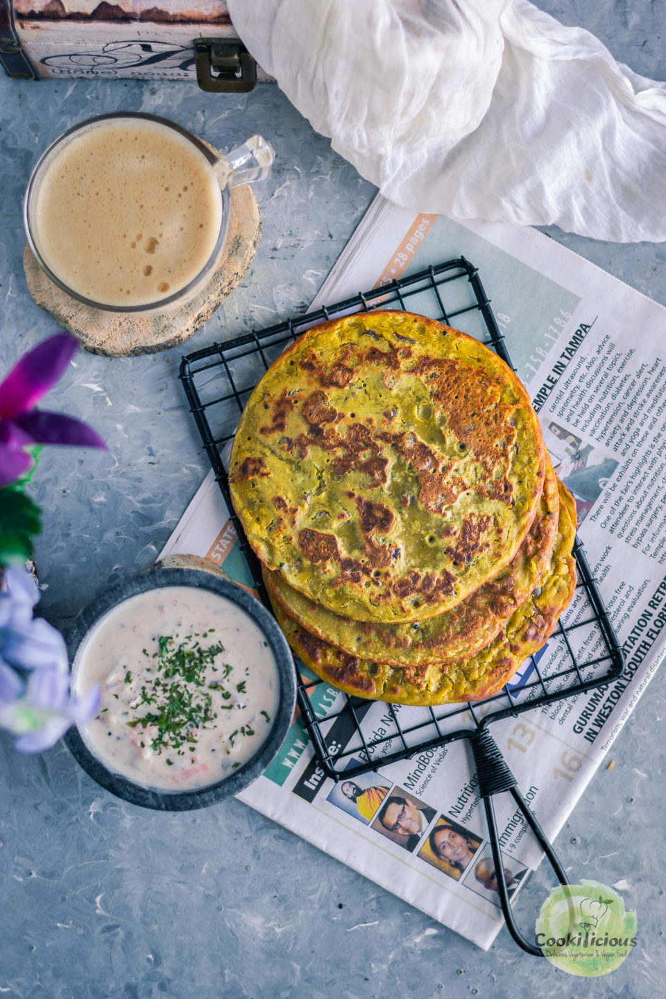 flat lay image of Lentil Pancakes with Leftover Dal with a bowl of yogurt dip and a coffee mug on the side