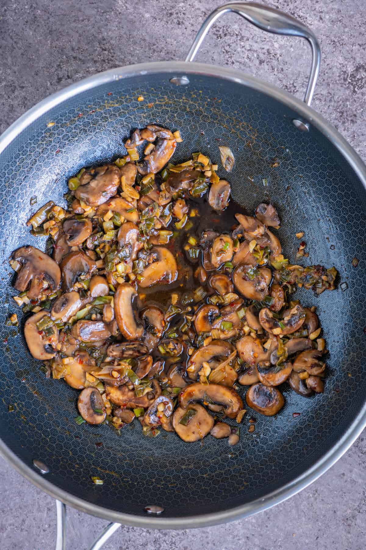 Coconut amino and rice vinegar added to mushrooms for Asian-style fried rice.