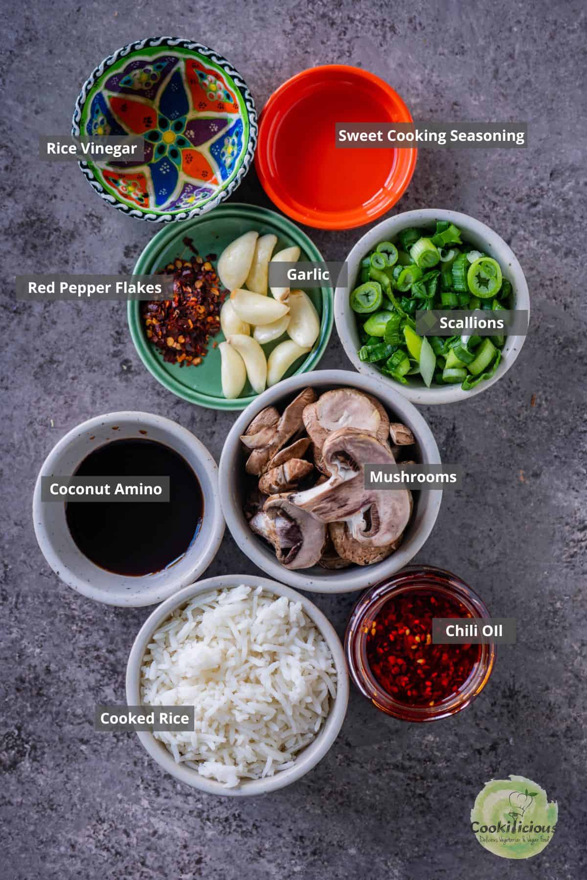 All the ingredients needed to make mushroom fried rice placed on a table with labels on them.