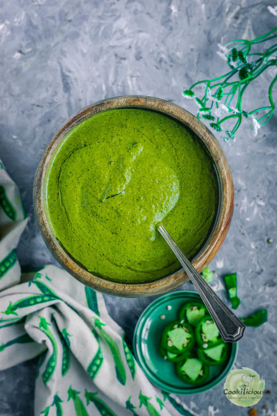 a bowl of Mint Cilantro Chutney with a spoon in it