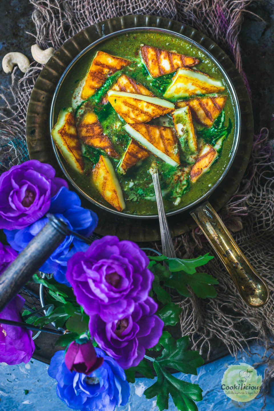 Restaurant Style Palak Paneer served in a bowl with flowers on the side