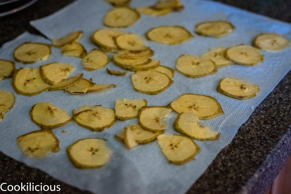 thinly sliced raw banana placed over a drying rack, ready to make Fried Raw Banana Vegan Chips