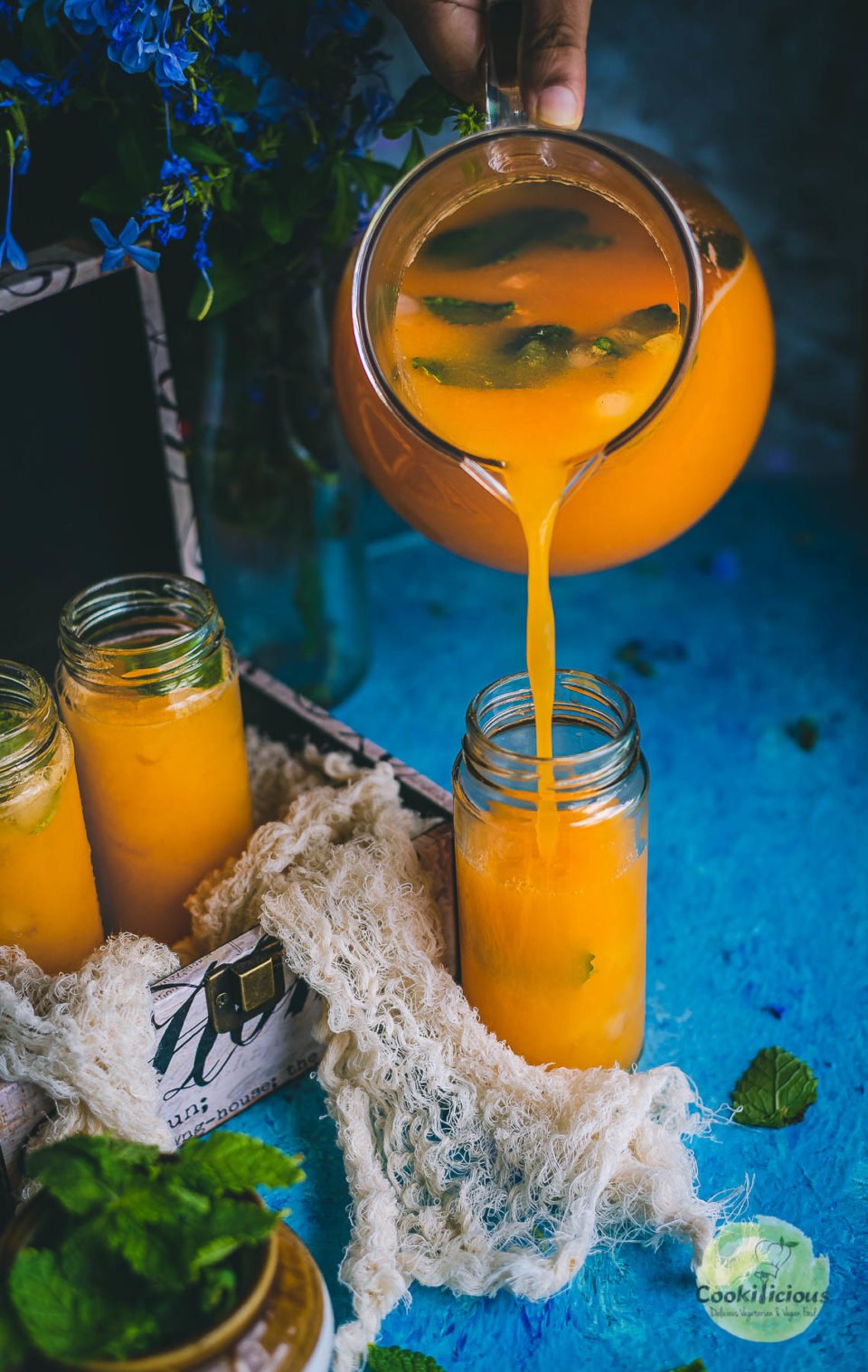 Organic Energy Drink With Carrots, Orange and Cantaloupe being poured from a jug into a glass