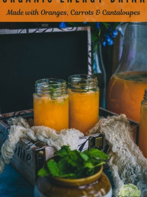 2 glasses filled with Organic Energy Drink With Carrots, Orange and Cantaloupe placed in a box and text at the top