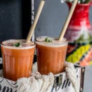 Homemade Carrot Orange Juice with straws in two glasses ready to drink.