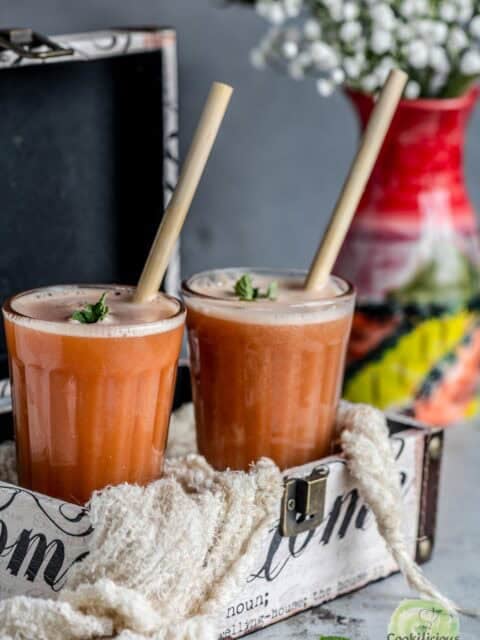 Homemade Carrot Orange Juice with straws in two glasses ready to drink.
