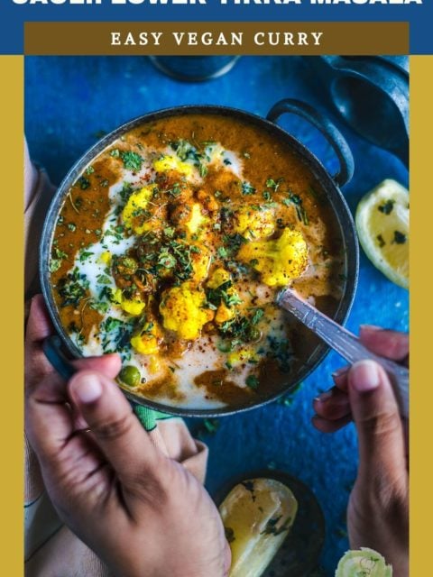 one hand holding the kadai while the other hand digs into the Cauliflower Tikka Masala - Easy Vegan Curry with a spoon and text at the top