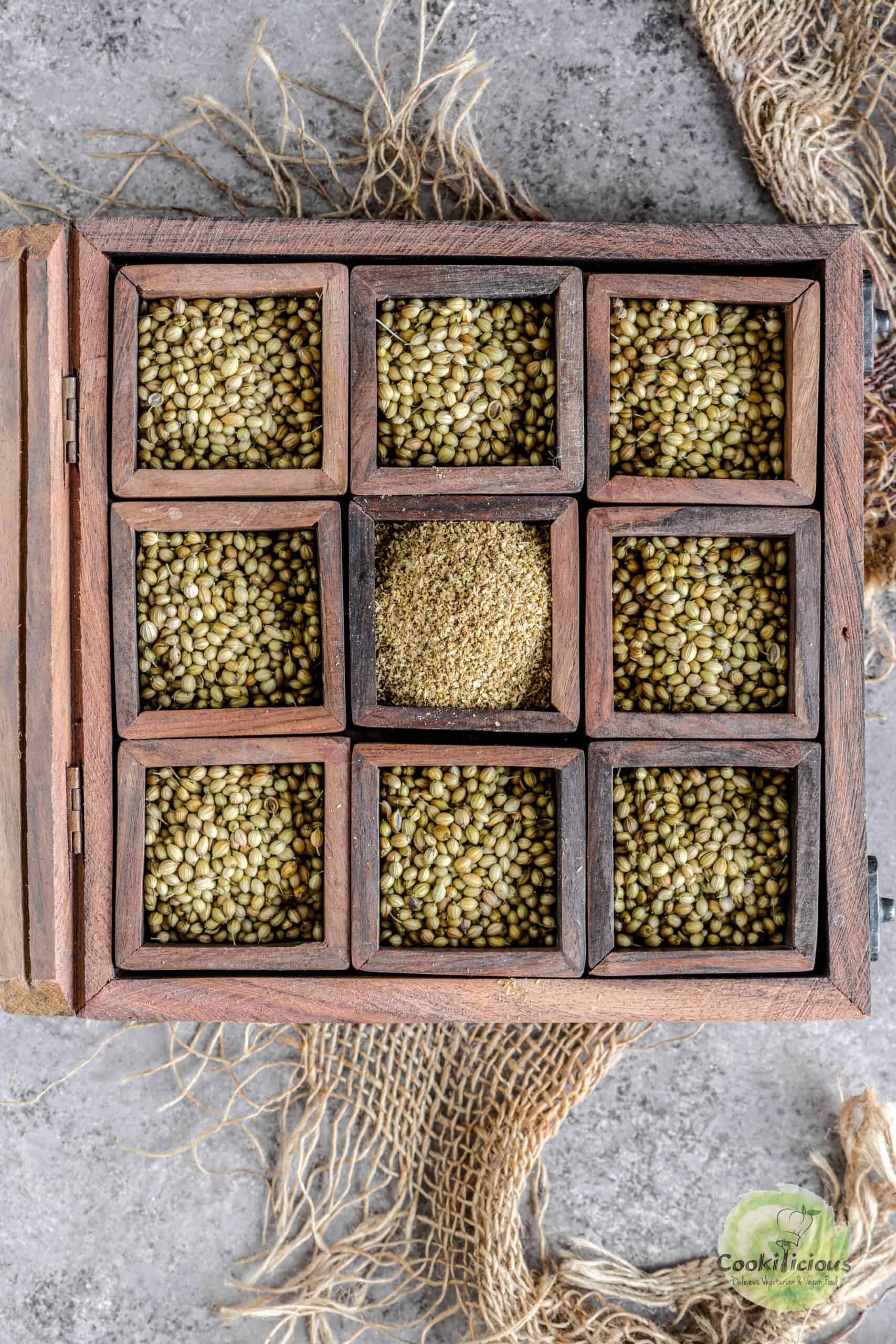 A masala dabba filled with coriander seeds and ground coriander.