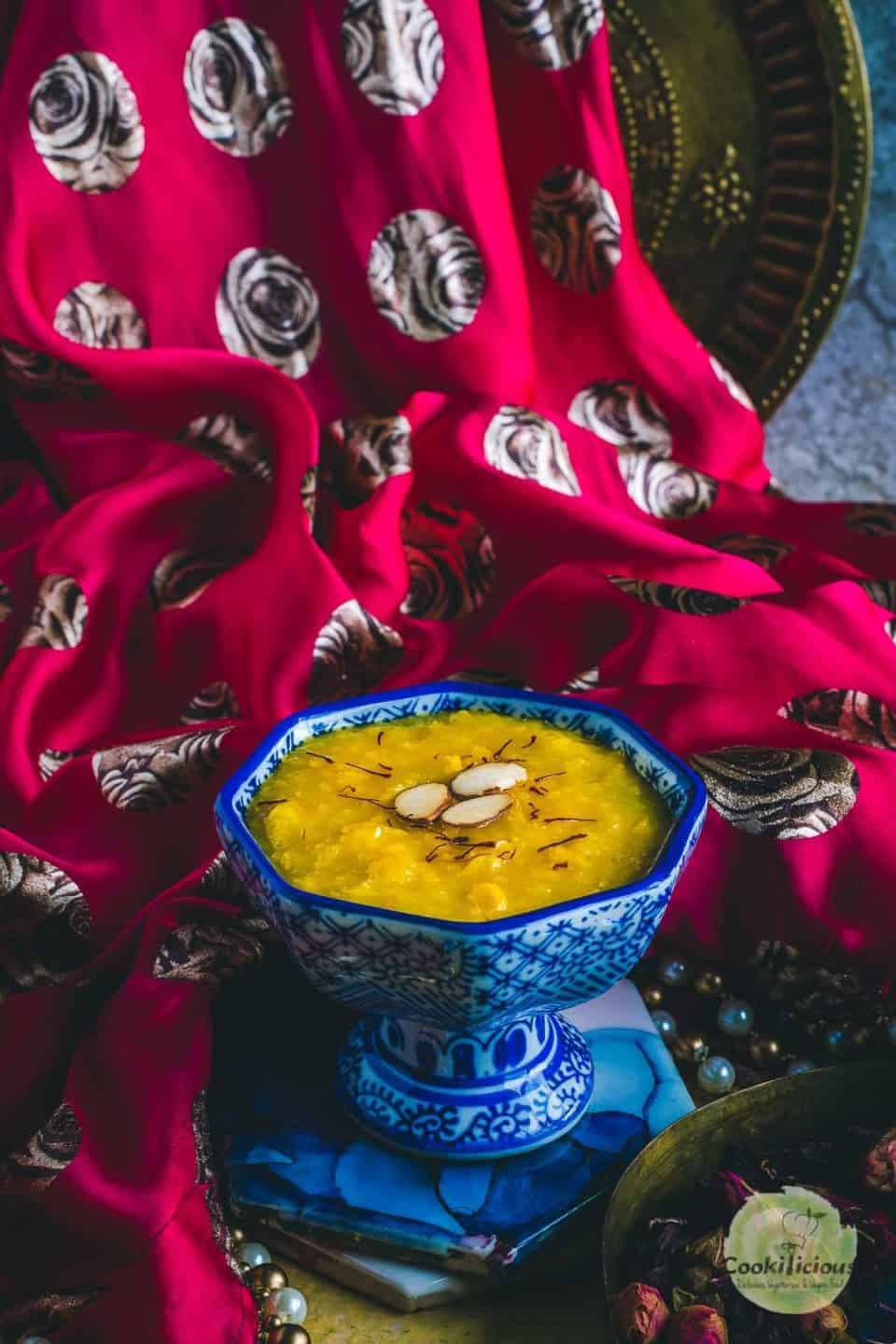 A decorative piece of cloth on the background of a bowl filled with Jhajhariya (vegan coconut milk pudding)