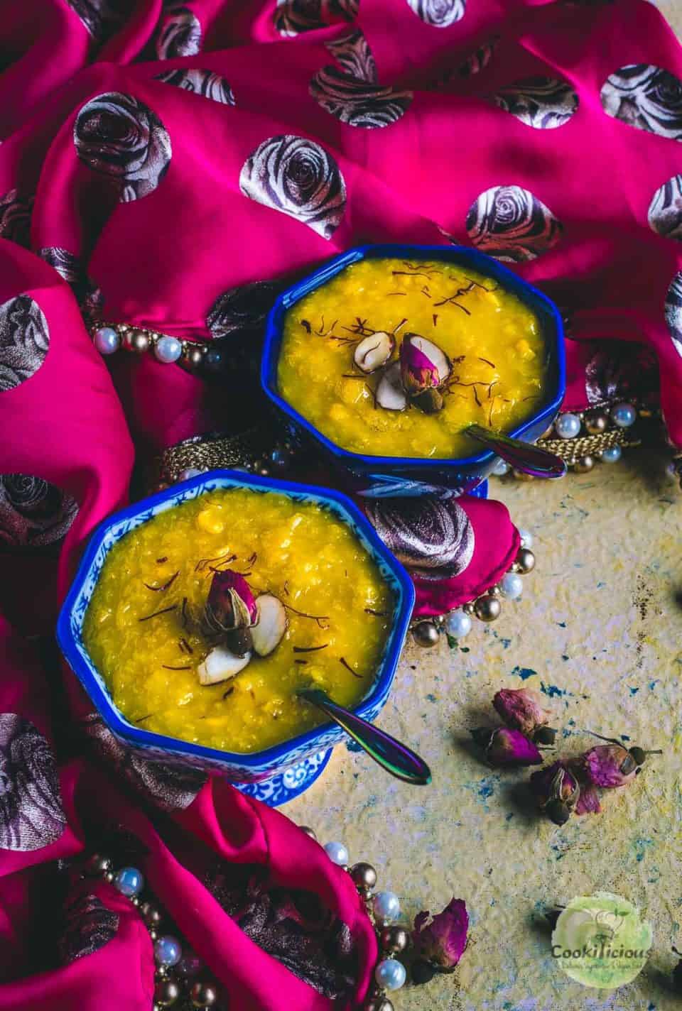 Jhajhariya (vegan corn and coconut milk pudding) served in 2 bowls with spoons in it