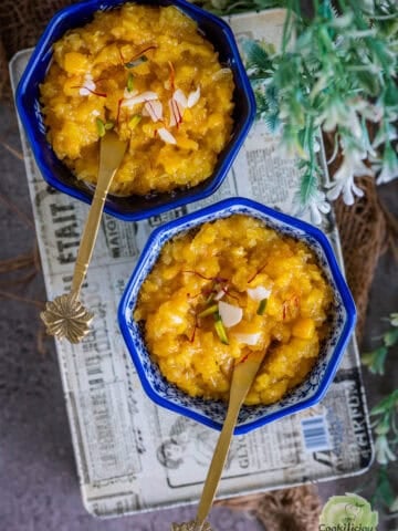 Indian Sweet Corn Pudding called Jhajariya served in 2 decorative bowls with spoons in them.