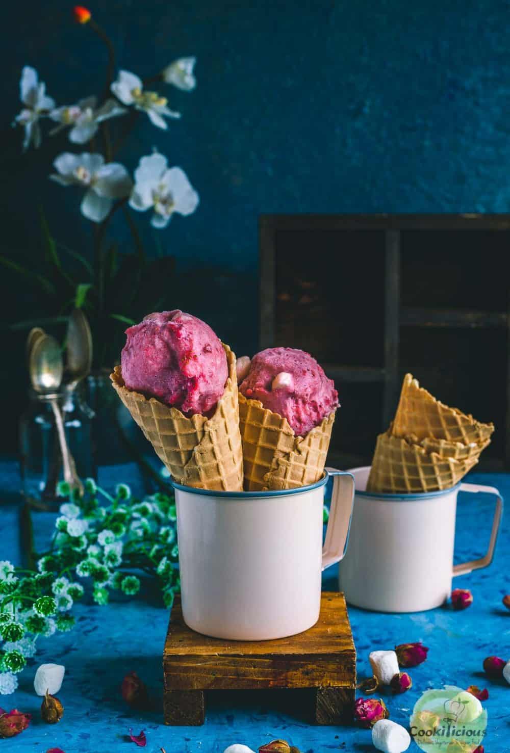 2 strawberry marshmallow ice cream cones placed in a mug
