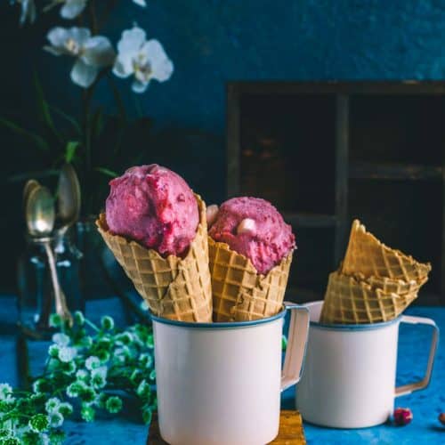 2 strawberry marshmallow ice cream cones placed in a mug