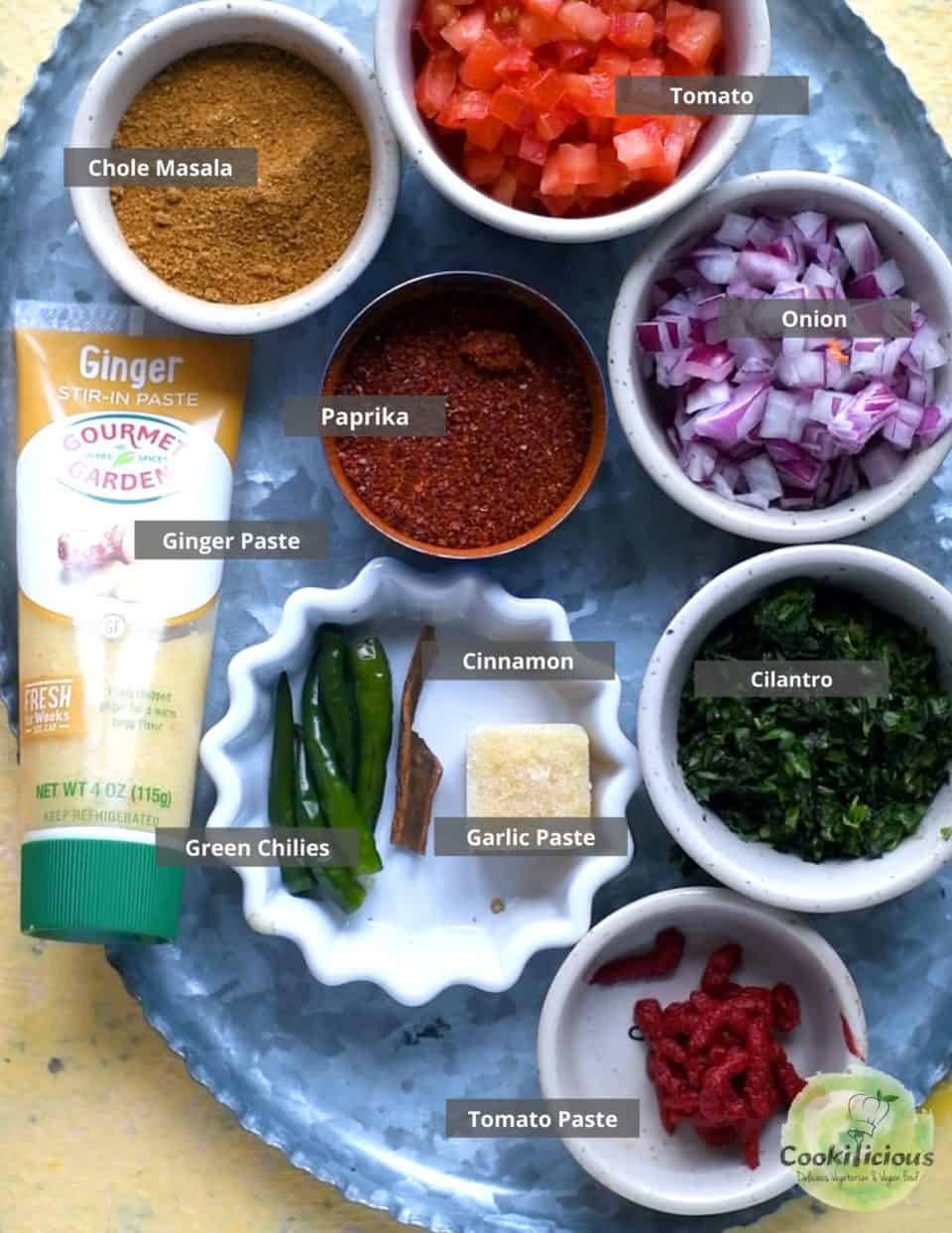 all the ingredients needed to make Vegan Chana Masala placed in a tray with labels on them