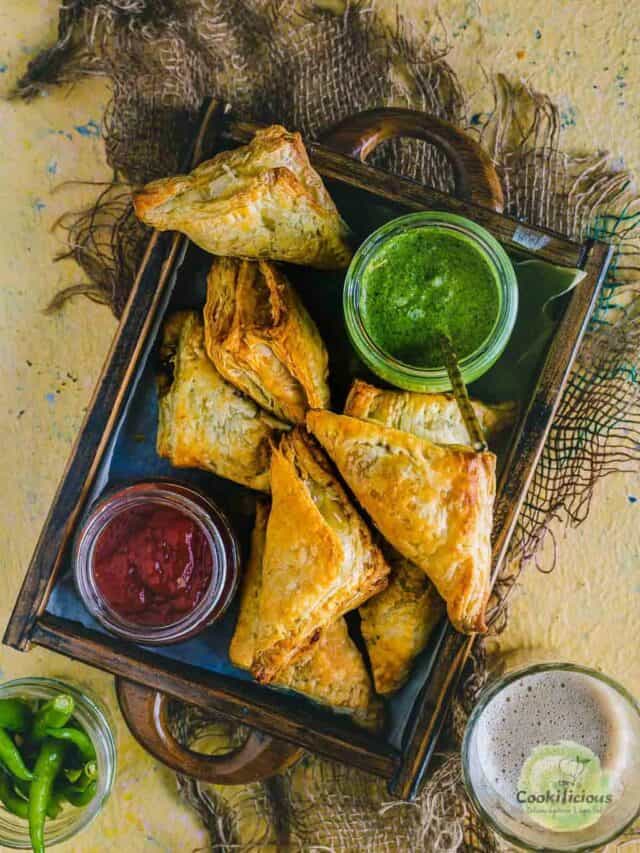 Vegetable Puff Pastry Samosa served in a tray with ketchup and chutney on the side