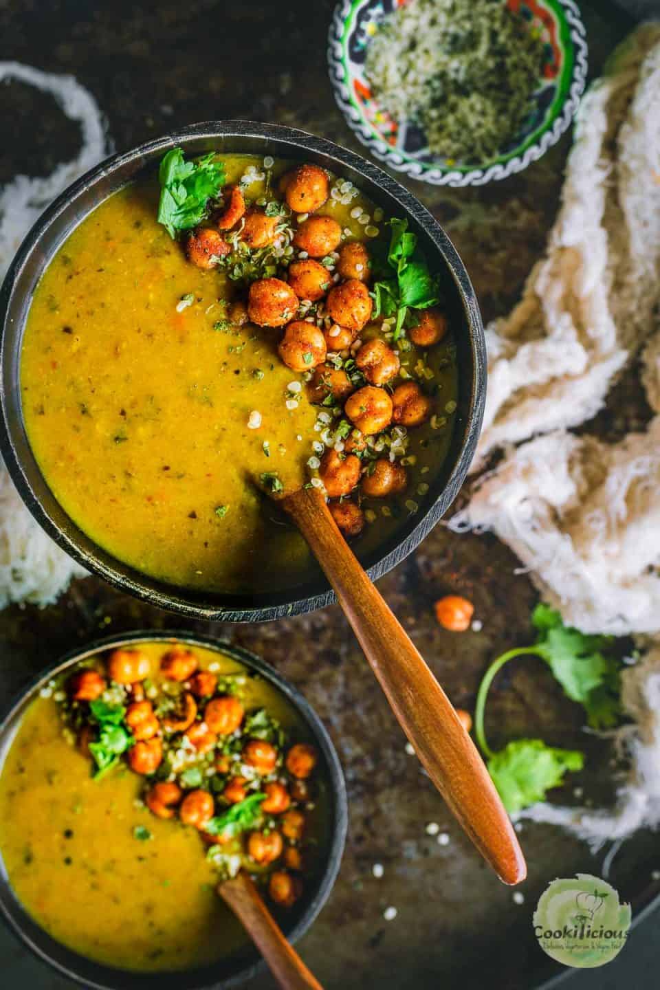 one wooden bowl filled with Vegan Lentil Soup | Indian Dal Shorba and a wooden spoon in it