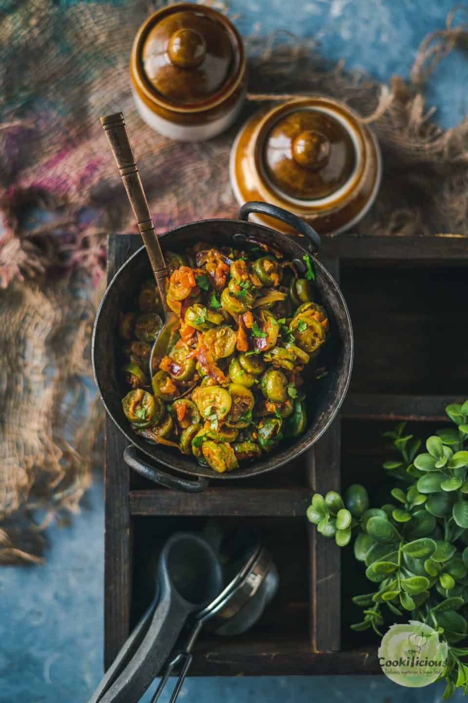 Ivy Gourd Garlic Stir-Fry served in a small kadai with a spoon in it