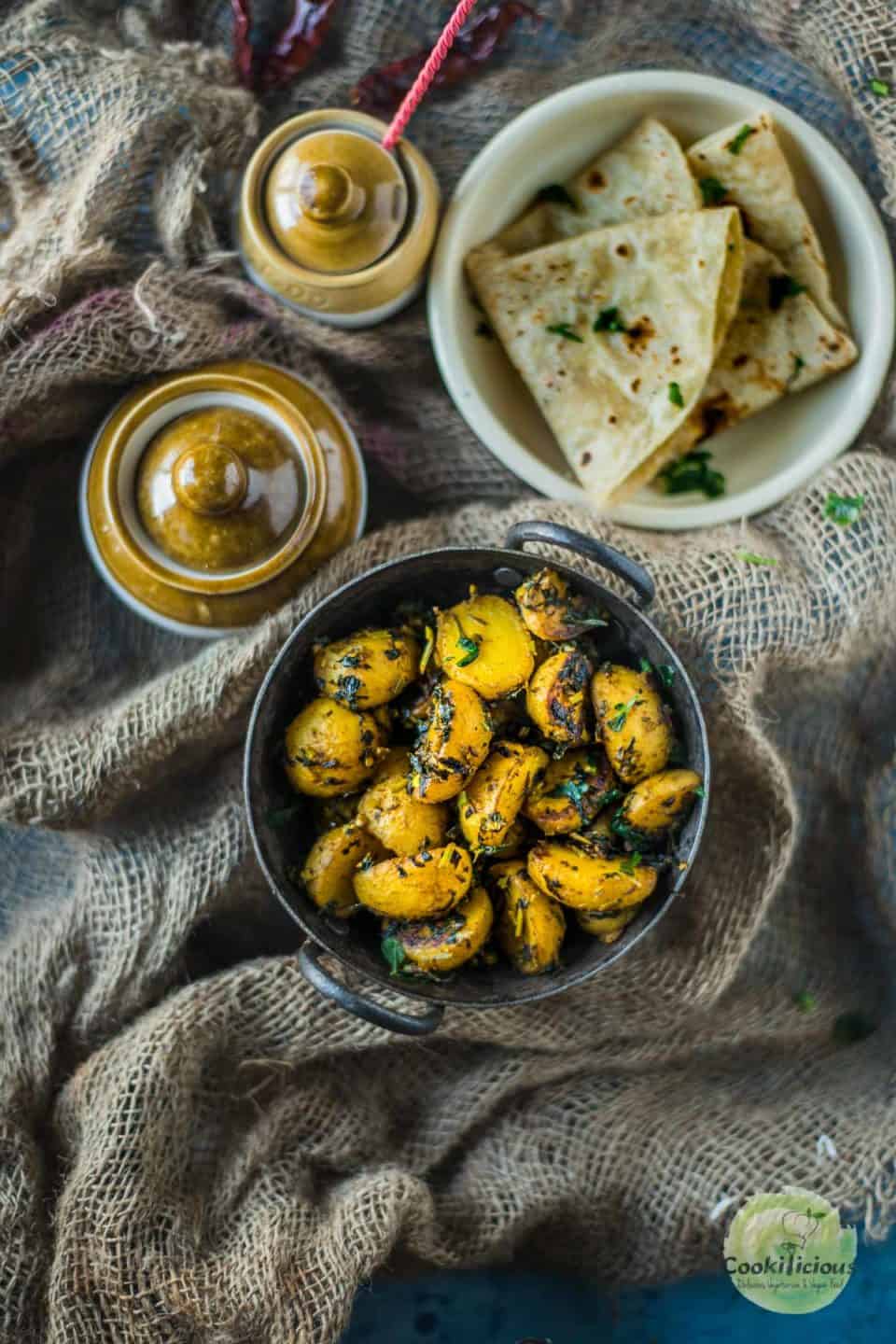 Aloo Methi served with chapati and pickle jars on the side