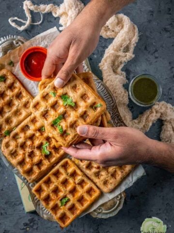 a set of hands holding one Vegan Savory Dosa Waffle