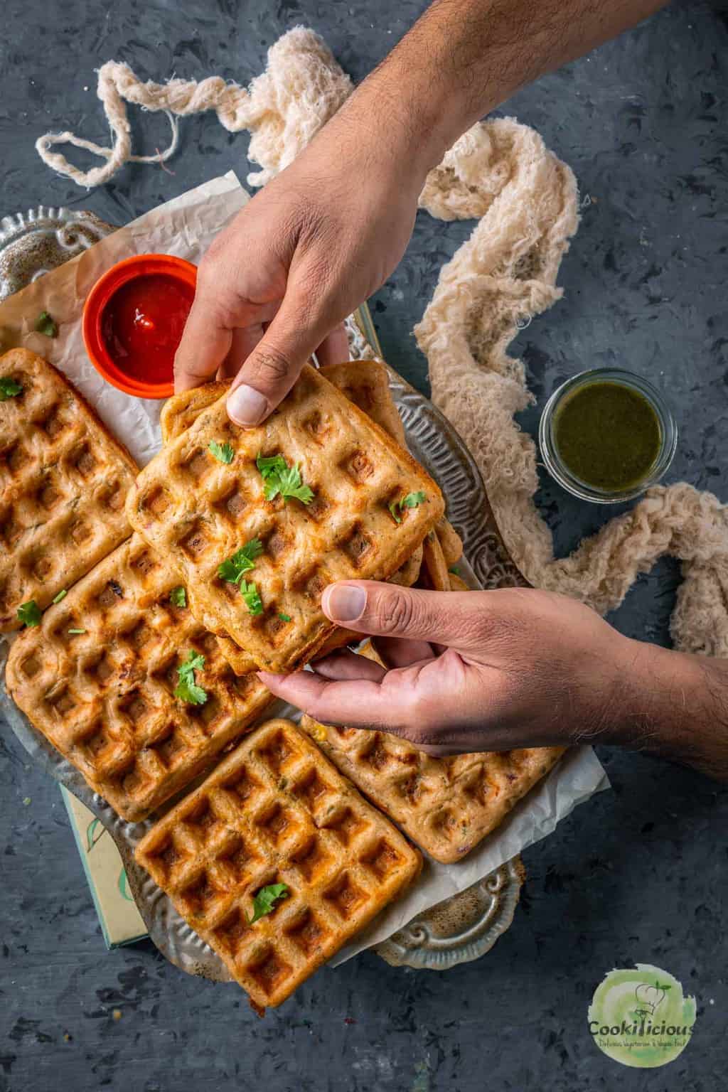 a set of hands holding one Vegan Savory Dosa Waffle