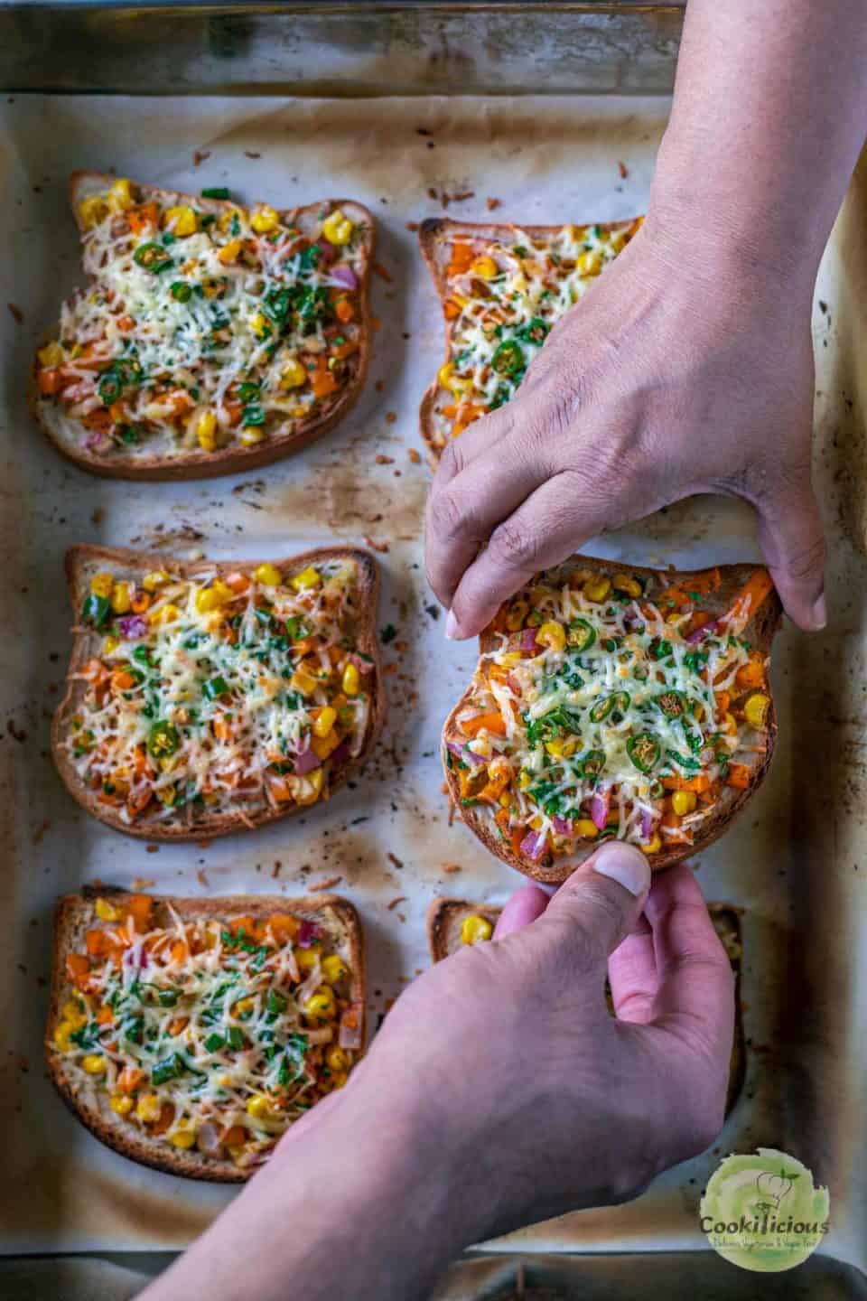 2 hands reaching for the same Vegan Chilli Cheese Corn Toast