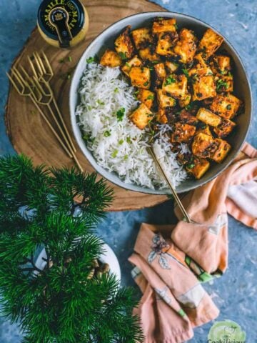 Honey Sriracha Tossed Paneer served in a plate with rice