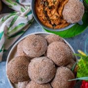 a bowl of Teff Idli With Beet Leaves served with chutney