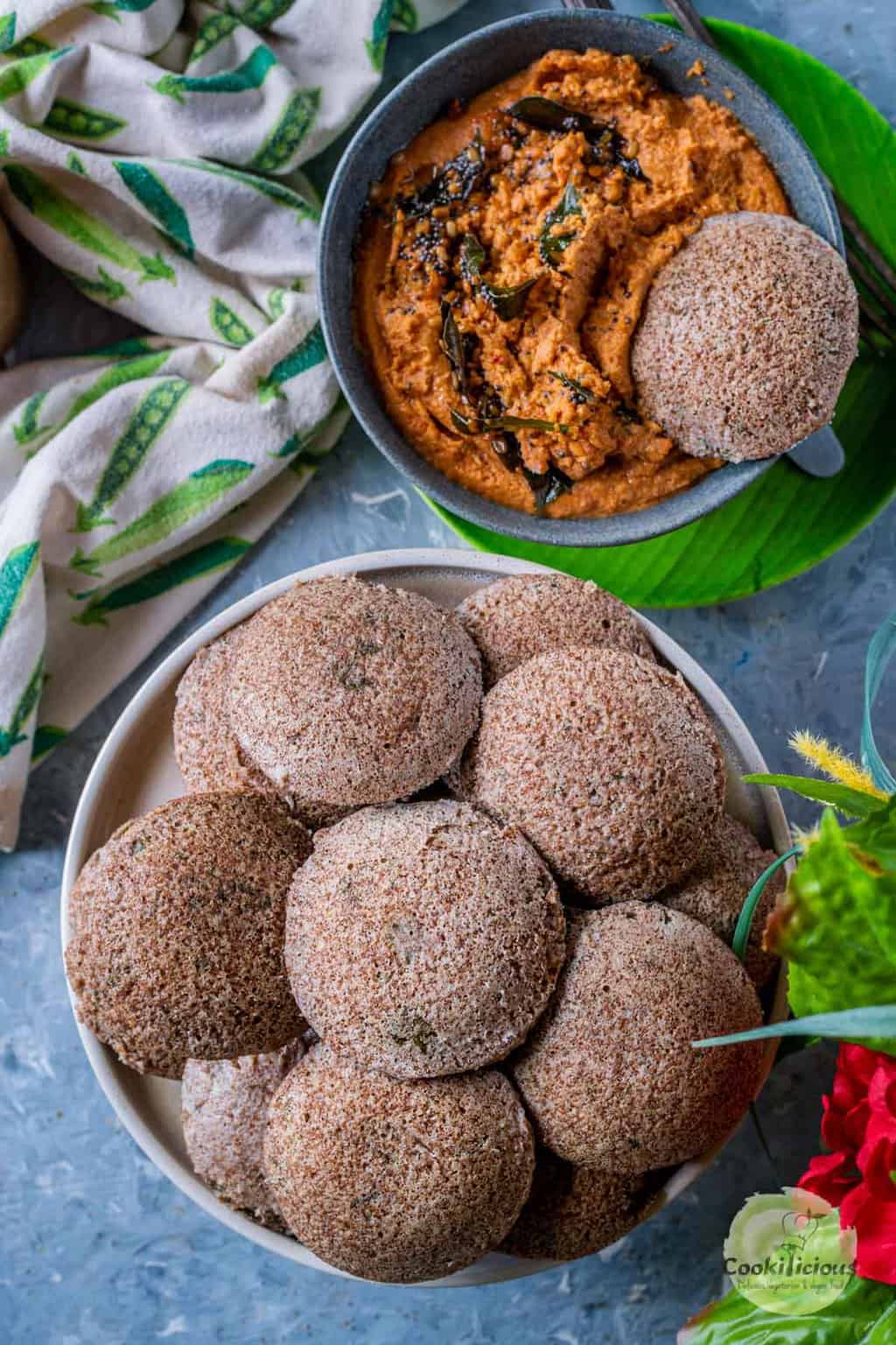a bowl of Teff Idli With Beet Leaves served with chutney
